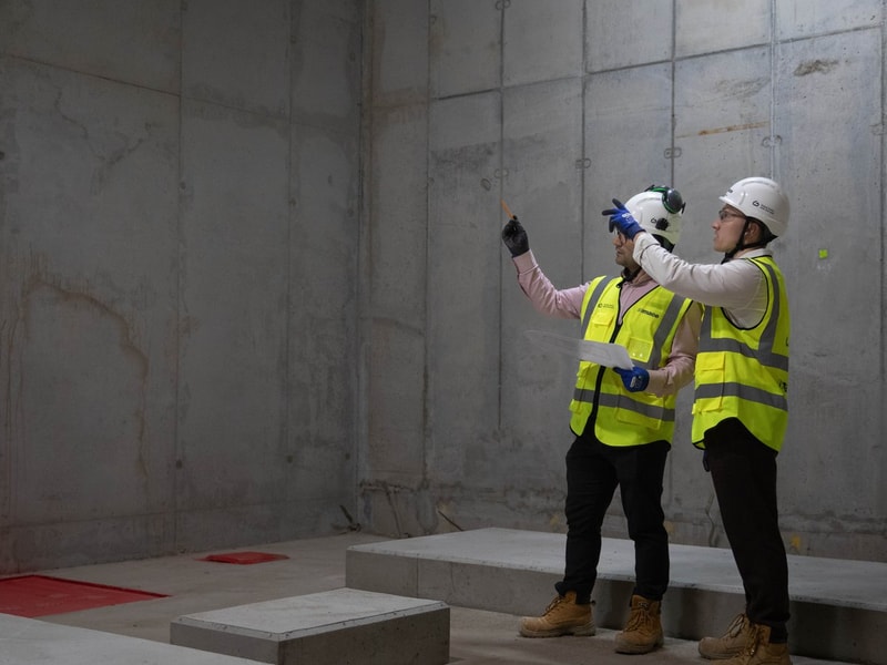 Two Mace employees inspecting construction progress in a concrete room